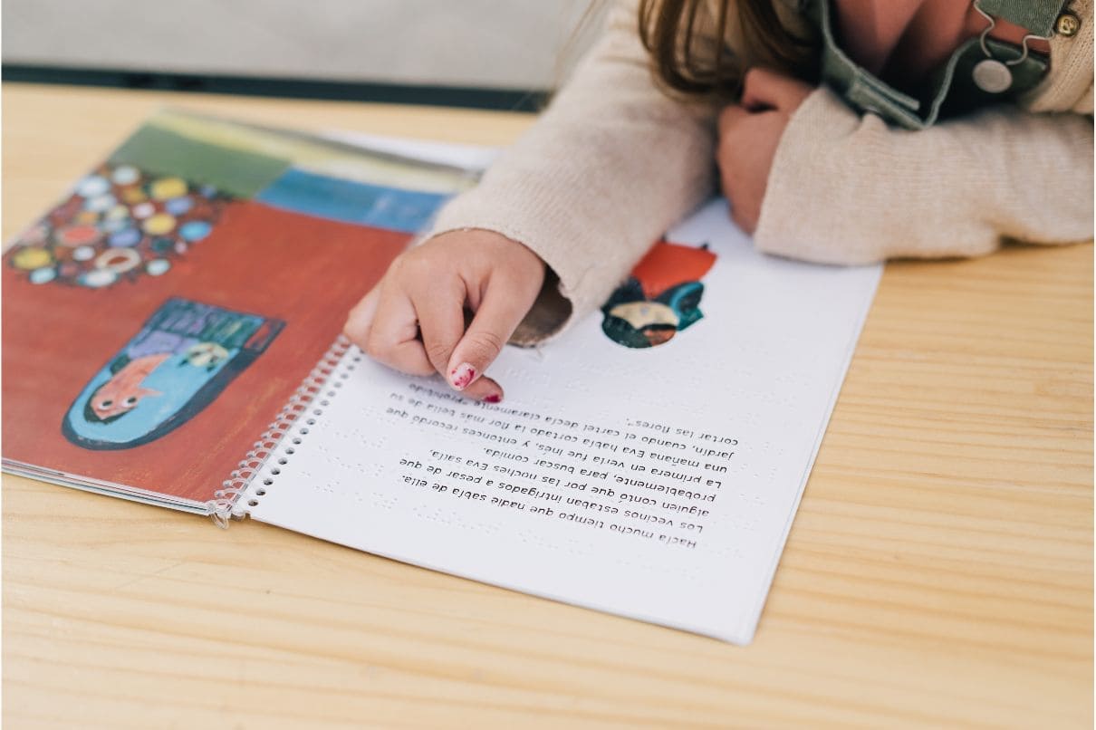 A child writing in a book with a picture of a cat, exploring their creativity and imagination